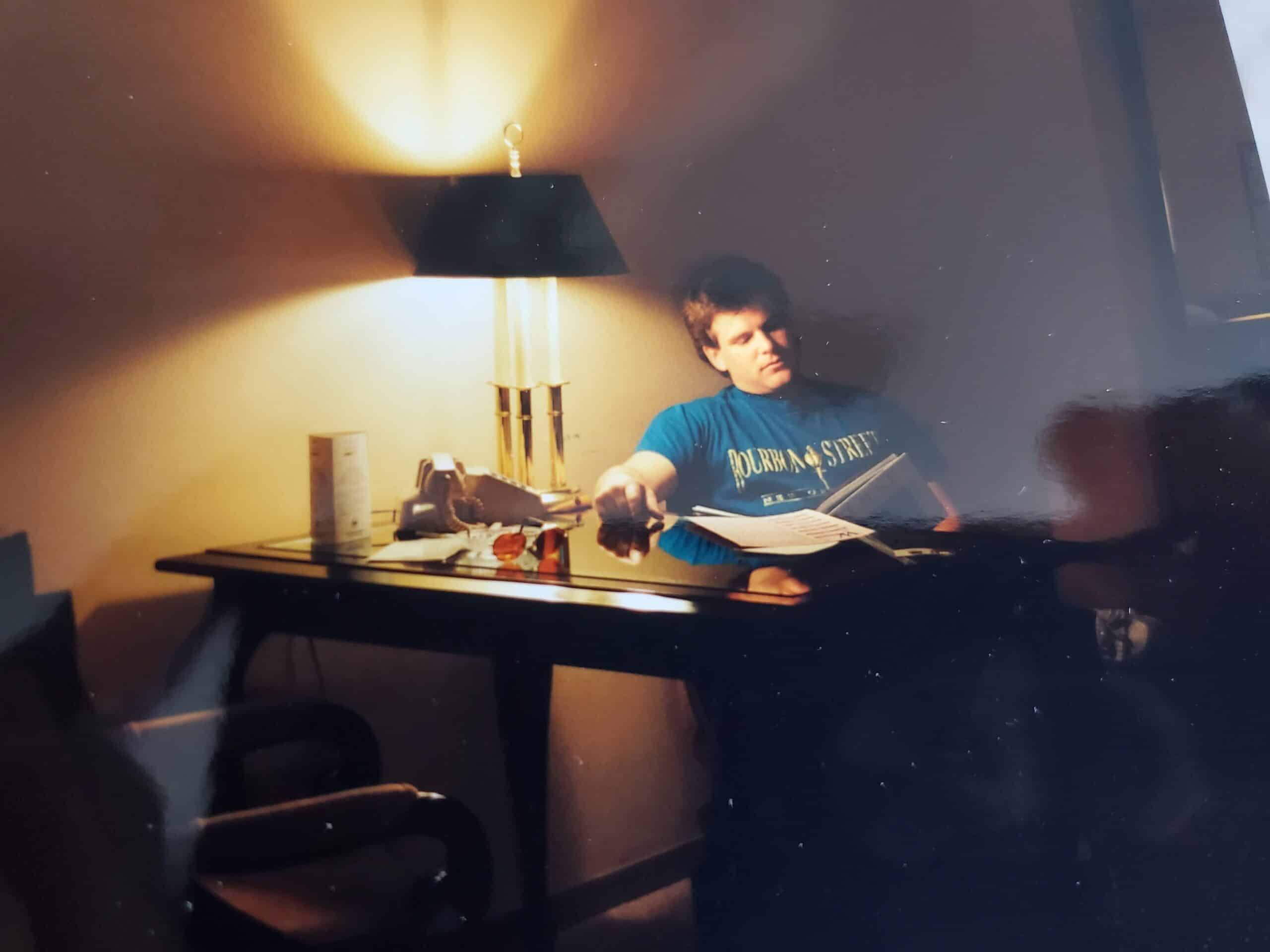 Michael Rogers seated at a quiet desk with a journal, reflecting on his story.